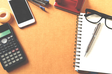 Overhead of office table with notebook, pen, mobile phone , calc