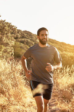 Young man jogging down a mountain