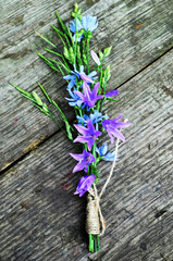 bunch of bells on a wooden background, wild flowers tied with a linen rope, flowers for the bride, place for your text, invitation card,