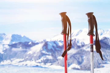 Foto op Canvas skiing in Alps, close up of two ski poles on mountains background © Song_about_summer