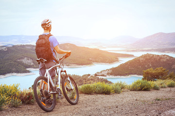 Fototapeta na wymiar cycling, mountain biking, man with bicycle enjoying panoramic view at sunset