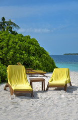 Naklejka na ściany i meble sun loungers on tropical beach by the ocean