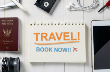 Travel Agency booking Banner with text Travel Book Now on book page. Travel equipment surrounding the Ring Binder with Travel book now message. 