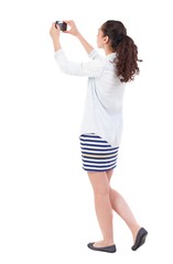 back view of standing curly woman with mobile phone in the hands of. girl  watching. Rear view people collection.  backside view of person.  Isolated over white background.  African-American woman