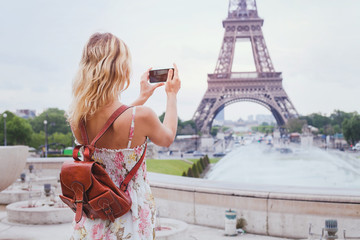 Naklejka premium turysta robiący zdjęcie wieży Eiffla w Paryżu aparatem kompaktowym lub smartfonem, podróżuje po Europie