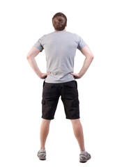 Back view of handsome man in t-shirt and  shorts  looking up.   Standing young tourist. Rear view...