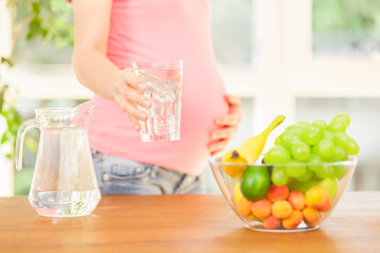 Pregnant woman drinking a glass of water
