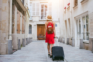travel background, woman tourist walking with suitcase on the street in european city, tourism in Europe - obrazy, fototapety, plakaty