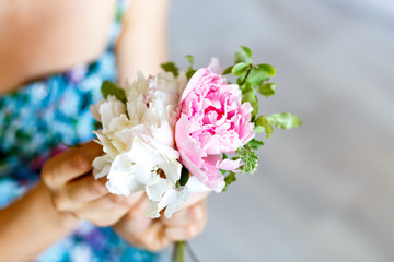 Florist making a bouguet of white flowers and peonies