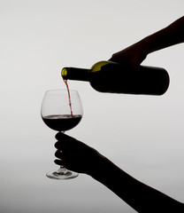 Frau gießt Wein ein