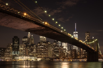 Fototapeta na wymiar The downtown Manhattan skyline and the Brooklyn Bridge at night