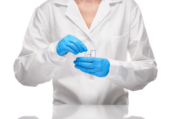 Doctor in gown and gloves holding glass ampoules with drug