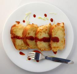 Garlic and herb bread slices with tomato sauce in white plate.