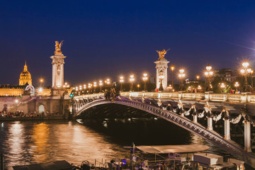 Paris by night, beautiful illumination of Alexandre III bridge on Seine river in the evening, historical architecture