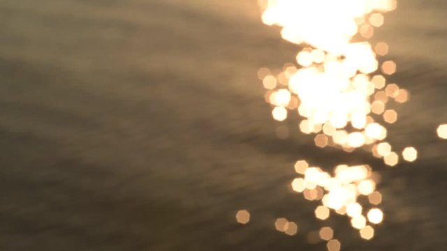 Sunlight glistens on the ocean at sunset