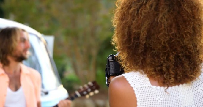 Woman taking a picture of a man playing guitar
