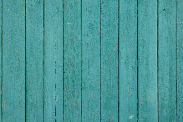 Fototapeta na wymiar Green wooden fence texture. Aged boards . Old wooden planks with broken surface, cracks and knots. Natural retro background.