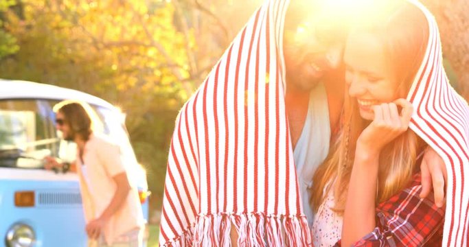 Couple hiding themselves under a scarf