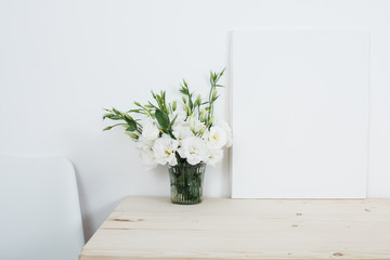 White interior decor, fresh natural flowers in vase and canvas