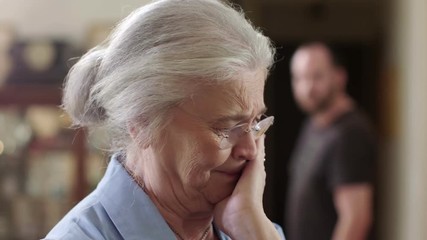 A senior woman who is a victim of elder abuse is in fear while an abusive man glares at her. Shot in 4K UHD.