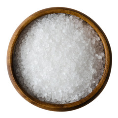 Sea salt in a wooden bowl on white background. Also called bay salt or solar salt, is used in...
