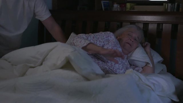 A senior woman in bed is shoved by an abusive man in an elder abuse, domestic violence scene. Shot in 4K UHD.