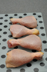 Four chicken drum sticks displayed on a white and black dot plat