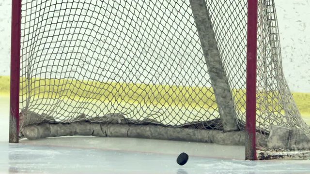 Slow motion shot of a hockey player shooting puck into goal