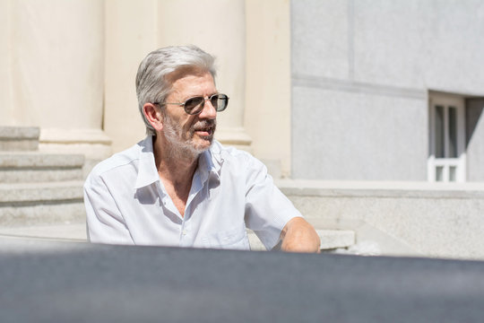 Fashionable Senior Man Sitting On Stairs