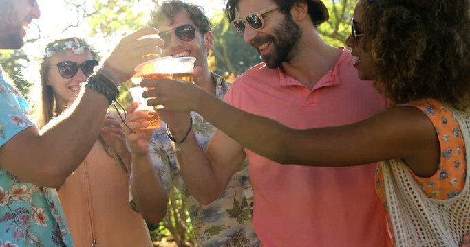 Group of hipster friends toasting with glasses of beer 