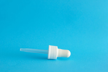 A dropper isolated on a blue background