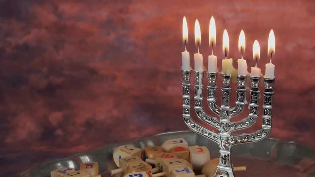 Chanukah candles all in a row. Bright, shiny multicolor candles for the Jewish holiday. All lit, isolated on a black background, horizontal view.

