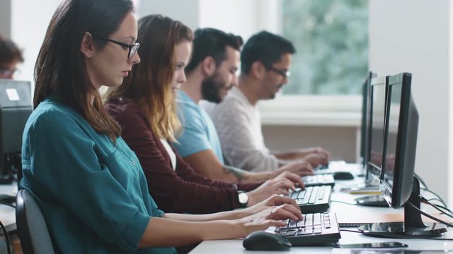 Group of Mixed Race Students are sitting in a Row in Computer Class and Working. Shot on RED Cinema Camera in 4K (UHD).