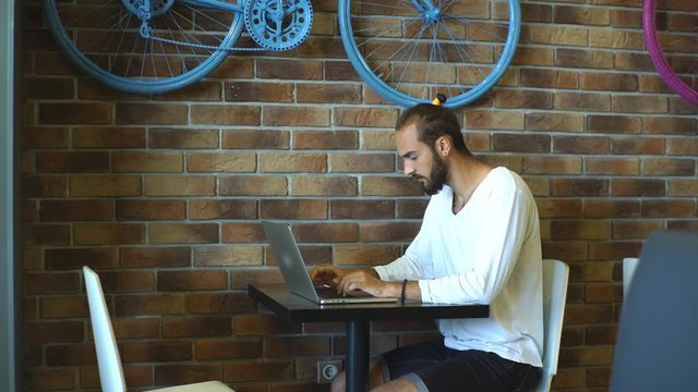 freelancer sitting in a cafe and uses the laptop