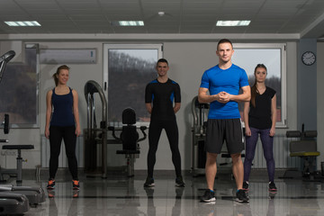 Fototapeta na wymiar Group Of Sportive People In A Gym Training