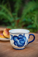 Tea set. Porcelain vintage cup and  teapot with cakes outdoors.