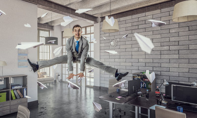 Obraz premium Jumping businessman in office . Mixed media