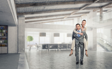 Businesswoman riding colleague back . Mixed media