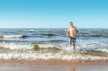 Fototapeta na wymiar Boy playing on the beach (Prince Edward Island, Canada)
