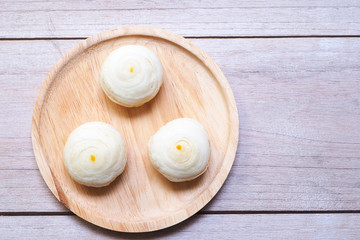 Top view of traditional chinese swirl mooncakes on a wooden plate.