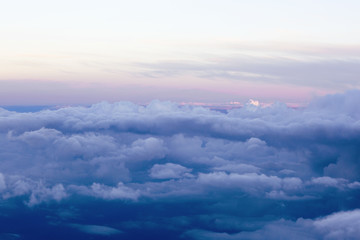 Fluffy clouds over the earth, the landscape. The scenic sky during sunset, the view from the air. 