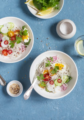 Rice noodles and vegetables salad. Healthy vegetarian food. On a blue background, top view