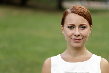 Fototapeta premium Caucasian woman in city park serious face portrait