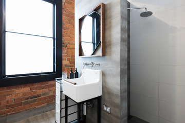 Renovated warehouse bathroom with vintage basin and walk in shower