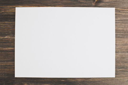 white paper on a wooden background, mock up