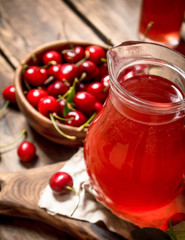 Fresh cherry juice .On wooden background.