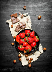 Strawberries with slices of chocolate and nuts.