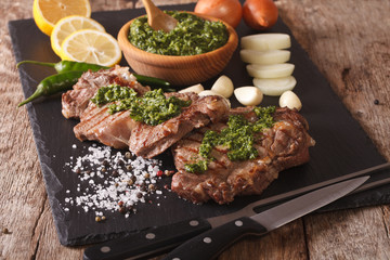grilled beef steak with chimichurri sauce on slate board. horizontal
