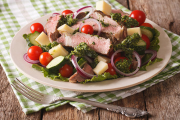 Sliced beef steak with a salad of fresh vegetables close-up. horizontal
