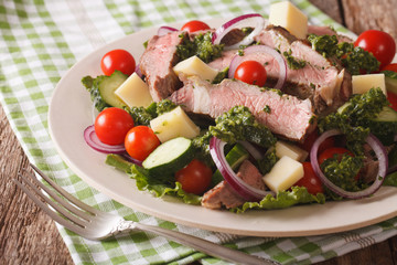 Salad with cheese, fresh vegetables and beef steak close-up on the table. Horizontal
